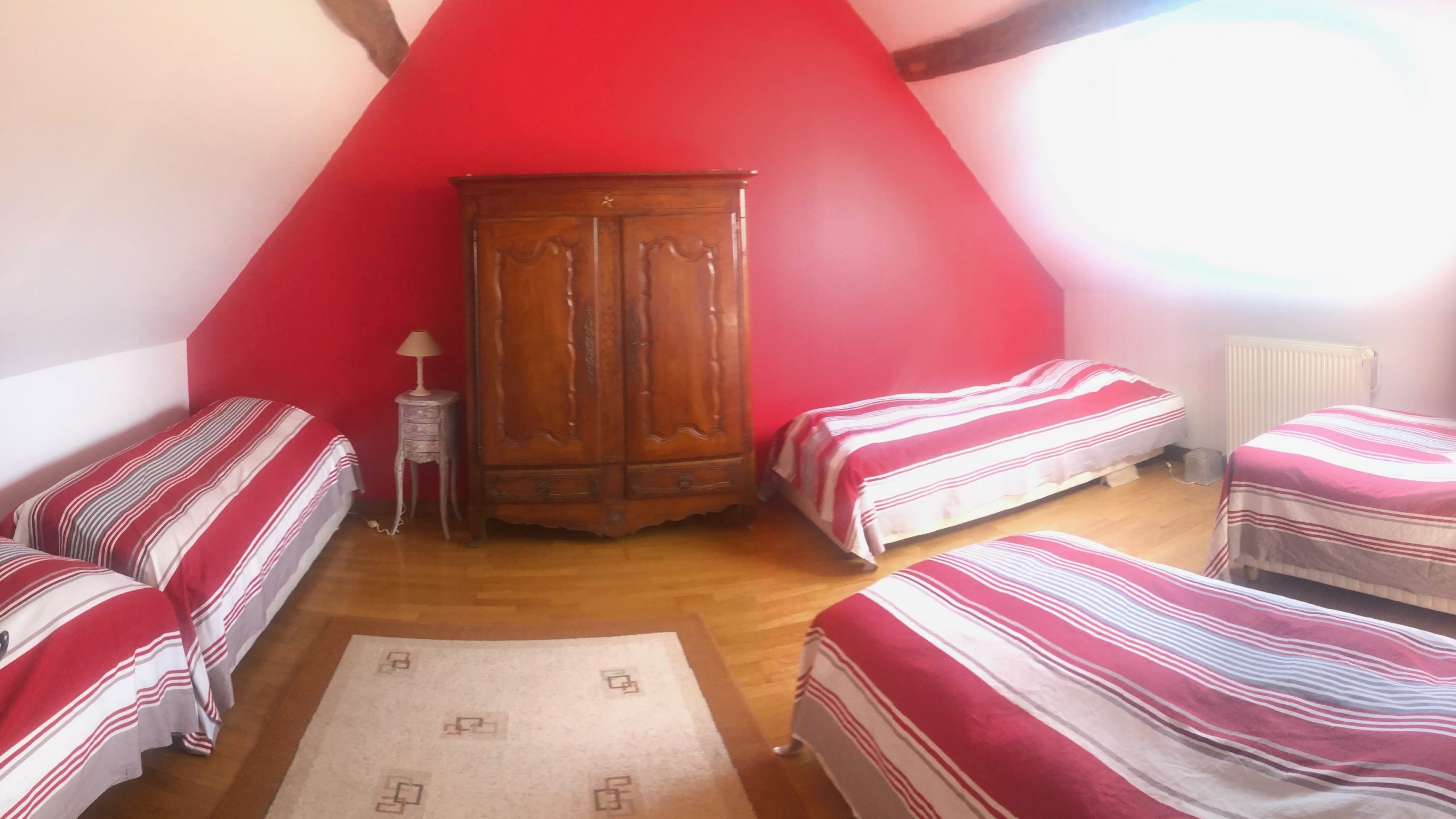 Chambre rouge avec plusieurs lits